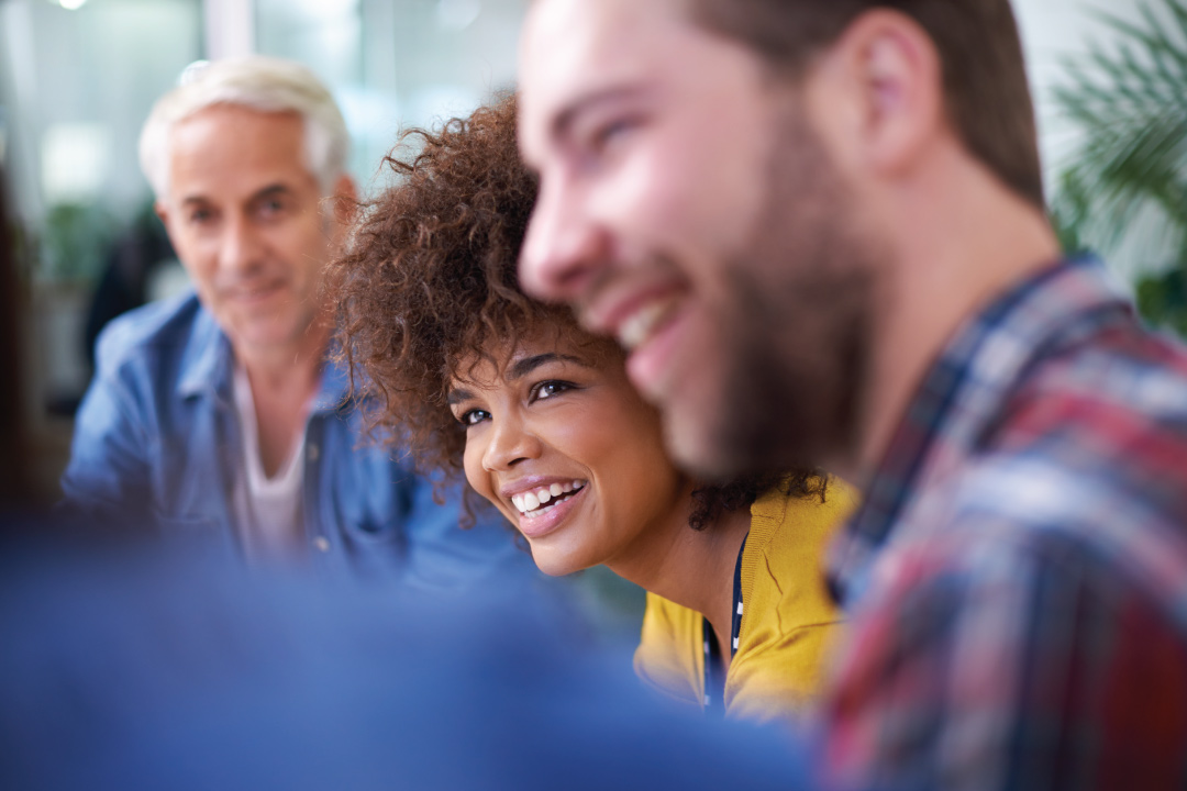 group of smiling people listening to each other